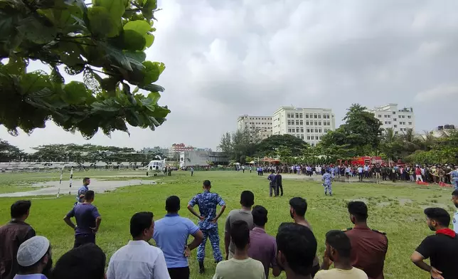 People gather at the site of a Bangladesh Air Force training aircraft crash in Dhaka, Bangladesh, Monday, July 21, 2025. (AP Photo/Mahmud Hossain Opu)