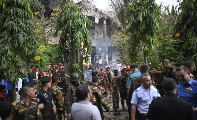 Firemen and security personnel look for the survivors after a Bangladesh Air Force training aircraft crashed into a school campus shortly after takeoff in Dhaka, Bangladesh, Monday, July 21, 2025. (AP Photo/Mahmud Hossain Opu)