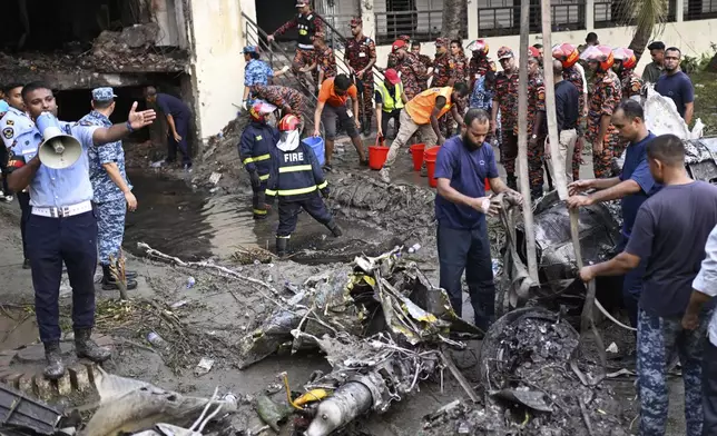 Firemen work at the site of a Bangladesh Air Force training aircraft that crashed into a school campus shortly after takeoff in Dhaka, Bangladesh, Monday, July 21, 2025. (AP Photo/Mahmud Hossain Opu)