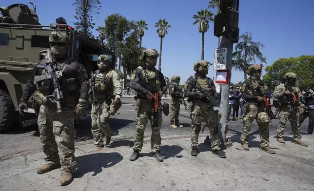 Federal agents stage at MacArthur Park Monday, July 7, 2025, in Los Angeles. (AP Photo/Damian Dovarganes)