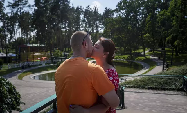 Ukrainian marine Stanislav Tarnavskyi kisses his girlfriend, Tetiana Baieva, in Irpin, Ukraine, Tuesday, July 8, 2025. (AP Photo/Evgeniy Maloletka)