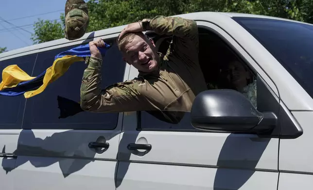 Ukrainian soldier Denys Zalizko, 21, greets his fellow villagers after returning from Russian captivity in Holovyno, Zhytomyr region, Ukraine, Monday, July 7, 2025. (AP Photo/Evgeniy Maloletka)