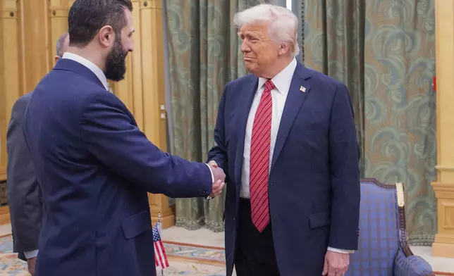 In this photo released by the Saudi Royal Palace, President Donald Trump, right, shakes hands with Syria's interim President Ahmad al-Sharaa, in Riyadh, Saudi Arabia, May 14, 2025. (Bandar Aljaloud/Saudi Royal Palace via AP)