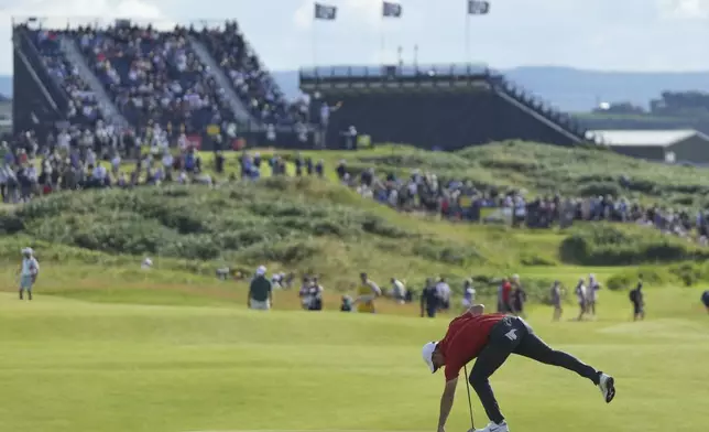 Rory McIlroy of Northern Ireland retrieves his ball on the 14th green during the third round of the British Open golf championship at the Royal Portrush Golf Club, Northern Ireland, Saturday, July 19, 2025. (AP Photo/Jon Super)