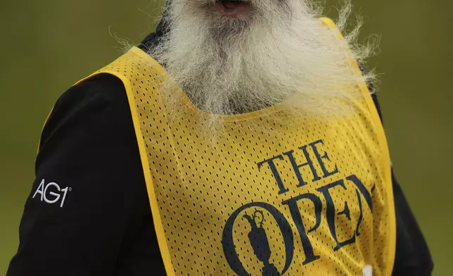 Nick Pugh, caddie for Lucas Herbert of Australia speak on the 7th green during the first round of the British Open golf championship at the Royal Portrush Golf Club, Northern Ireland, Thursday, July 17, 2025. (AP Photo/Francisco Seco)