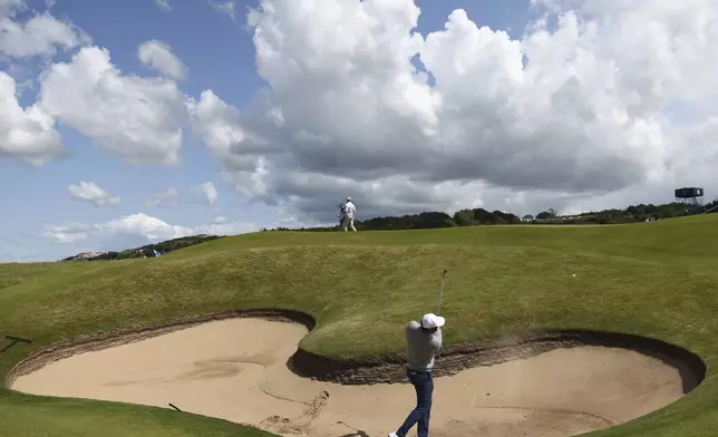 Scottie Scheffler of the United States plays out of a bunker on the 16th hole during a practice round for the 2025 British Open golf championship at the Royal Portrush Golf Club, Northern Ireland, Monday, July 14, 2025. (AP Photo/Peter Morrison)