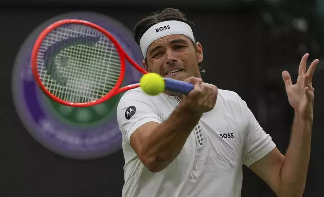 Taylor Fritz of the U.S. plays a return to Jordan Thompson of Australia during their men's singles fourth round match at the Wimbledon Tennis Championships in London, Sunday, July 6, 2025.(AP Photo/Joanna Chan)