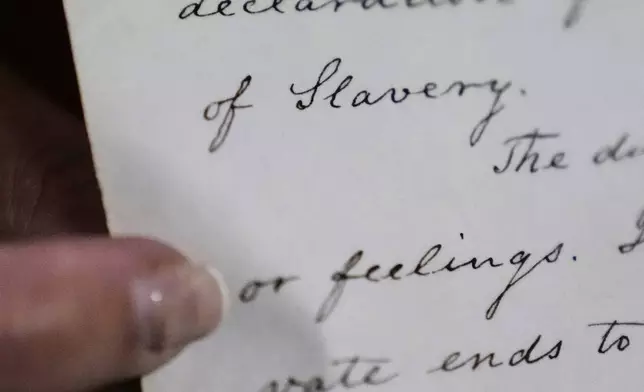 Historian Jennifer Cromack points out the word "Slavery" on a recently found, 178-year-old anti-slavery scroll at Grotonwood, the home mission of The American Baptist Churches of Massachusetts, Thursday, June 26, 2025, in Groton, Mass. (AP Photo/Charles Krupa)