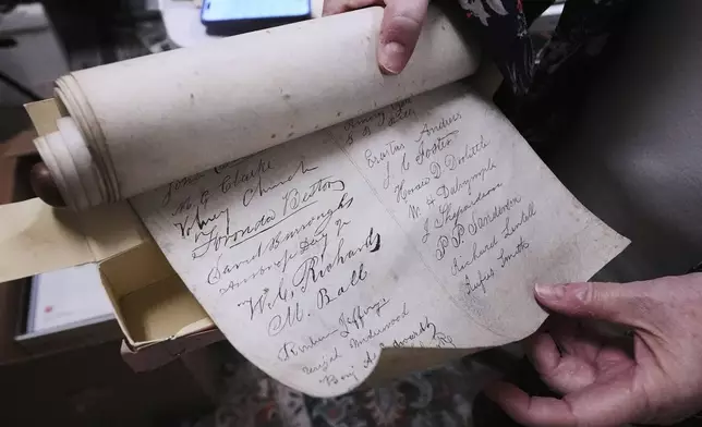Rev. Diane Badger unfurls a recently found, 178-year-old anti-slavery scroll at Grotonwood, the home mission of The American Baptist Churches of Massachusetts, Thursday, June 26, 2025, in Groton, Mass. (AP Photo/Charles Krupa)