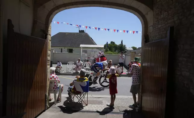 Supporters watch Quinn Simmons of the U.S. during the fifth stage of the Tour de France cycling race, an indivdual time-trial over 33 kilometers (20.5 miles) with start and finish in Caen, France, Wednesday, July 9, 2025. (AP Photo/Mosa'ab Elshamy)