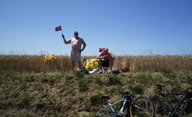 Fans holds flags of Norway during the fifth stage of the Tour de France cycling race, an indivdual time-trial over 33 kilometers (20.5 miles) with start and finish in Caen, France, Wednesday, July 9, 2025. (AP Photo/Mosa'ab Elshamy)