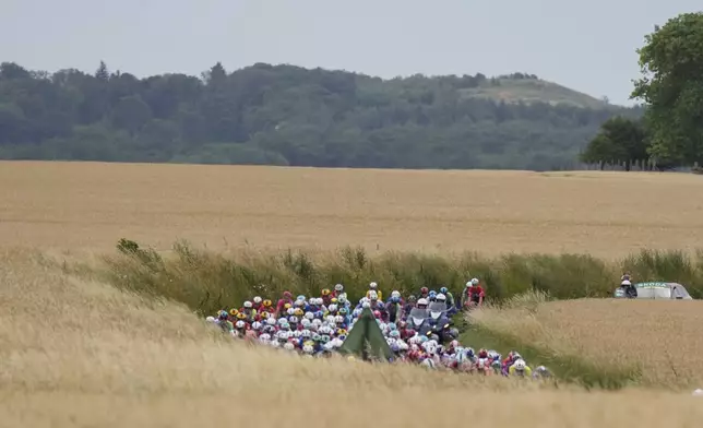 The pack rides during the first stage of the Tour de France cycling race over 184.9 kilometers (114.9 miles) with start and finish in Lille, France, Saturday, July 5, 2025. (AP Photo/Mosa'ab Elshamy)
