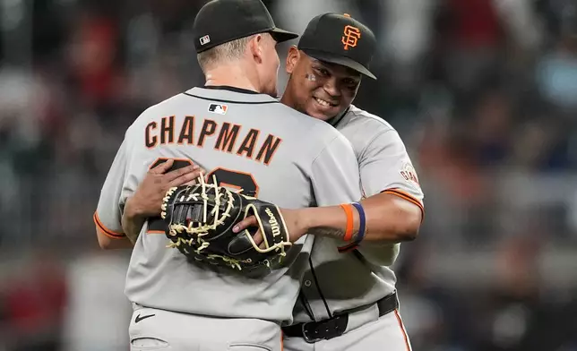San Francisco Giants' Matt Chapman (26) and Rafael Devers embrace after a baseball game against the Atlanta Braves, Tuesday, July 22, 2025, in Atlanta. (AP Photo/Mike Stewart)
