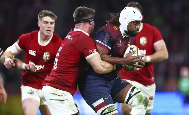 Queensland Reds' Seru Uru is tackled by Tom Curry of the British &amp; Irish Lions during their game in Brisbane, Australia, Wednesday, July 2, 2025. (AP Photo/Pat Hoelscher)