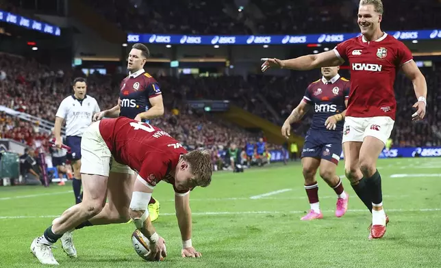 Tommy Freeman, left, of the British &amp; Irish Lions scores his team's first try as teammate Duhan van der Merwe reacts during their game against the Queensland Reds in Brisbane, Australia, Wednesday, July 2, 2025. (AP Photo/Pat Hoelscher)