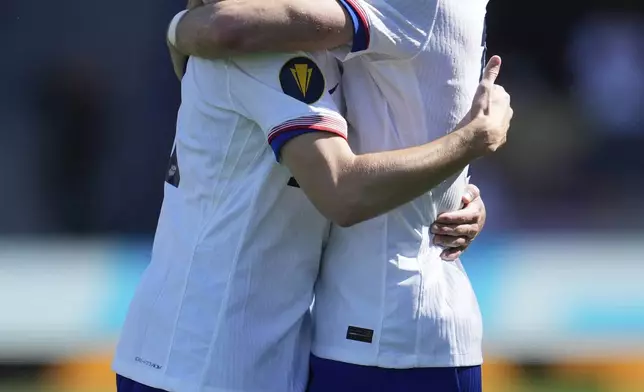 CORRECTS ID AT RIGHT, TO MAX ARFSTEN, NOT PAXTEN AARONSON - United States midfielder Brenden Aaronson, left, is congratulated by Max Arfsten after scoring against Trinidad and Tobago during the second half of a CONCACAF Gold Cup soccer match in San Jose, Calif., Sunday, June 15, 2025. (AP Photo/Jeff Chiu)