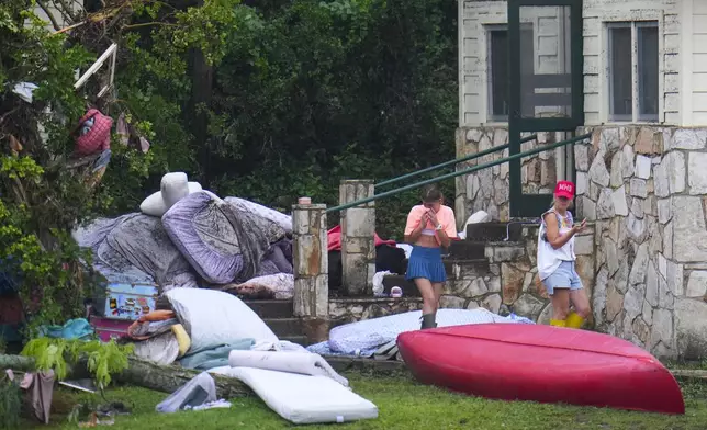 A person reacts while looking at the belongings outside sleeping quarters at Camp Mystic along the banks of the Guadalupe River after a flash flood swept through the area Sunday, July 6, 2025, in Hunt, Texas. (AP Photo/Julio Cortez)