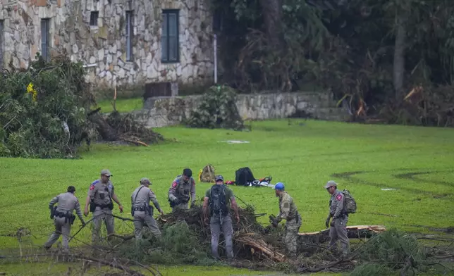 Officials search on the grounds of Camp Mystic along the banks of the Guadalupe River after a flash flood swept through the area Sunday, July 6, 2025, in Hunt, Texas. (AP Photo/Julio Cortez)