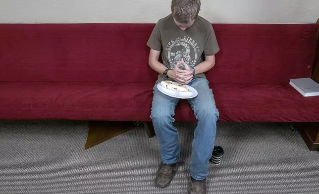 Hayden Turner prays during church services at the Hunt Baptist Church on Sunday, July 6, 2025, in Hunt, Texas. The small town of Hunt sits on the bank of the Guadalupe River and was severely damaged by recent flooding. (AP Photo/Rodolfo Gonzalez)