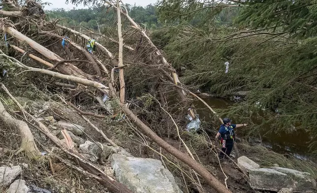 First responders from College Station Fire Department search along the banks of the Guadalupe River, as rescue efforts continue following extreme flooding, Sunday, July 6, 2025, in Ingram, Texas. (AP Photo/Rodolfo Gonzalez)