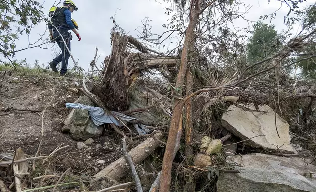 First responders from College Station Fire Department search along the banks of the Guadalupe River, as rescue efforts continue following extreme flooding, Sunday, July 6, 2025, in Ingram, Texas. (AP Photo/Rodolfo Gonzalez)