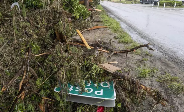 A road sign for the Hunt Post Office lies on the the side of Highway 39 after the post office was destroyed by recent flooding along the Guadalupe River on Sunday, July 6, 2025, in Hunt, Texas. (AP Photo/Rodolfo Gonzalez)
