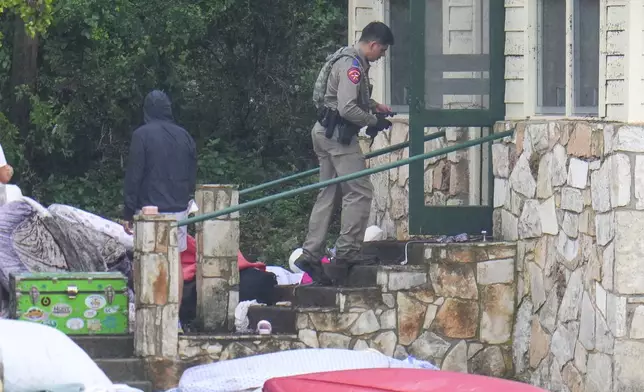 A Texas Department of Public Safety official enters sleeping quarters at Camp Mystic along the banks of the Guadalupe River after a flash flood swept through the area Sunday, July 6, 2025, in Hunt, Texas. (AP Photo/Julio Cortez)