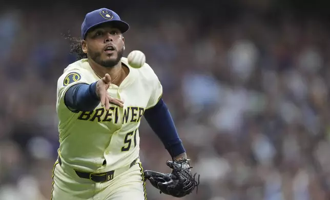 Milwaukee Brewers' Freddy Peralta tosses the ball to first base during the sixth inning of a baseball game against the Los Angeles Dodgers, Monday, July 7, 2025, in Milwaukee. (AP Photo/Aaron Gash)