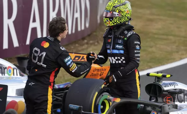 McLaren driver Lando Norris of Britain, right, is congratulated by his teammate Oscar Piastri of Australia after winning the British Formula One Grand Prix race at the Silverstone racetrack in Silverstone, England, Sunday, July 6, 2025. (AP Photo/Darko Bandic)