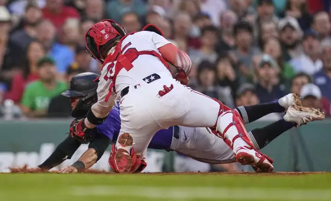 Colorado Rockies' Tyler Freeman is tagged out at the plate by Boston Red Sox catcher Carlos Narvaez during the fourth inning of a baseball game at Fenway Park, Wednesday, July 9, 2025, in Boston. (AP Photo/Charles Krupa)