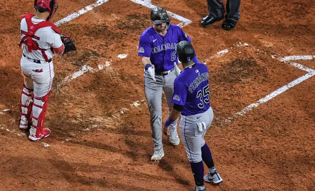 Colorado Rockies' Kyle Farmer, center, is congratulated after his two-run home run against the Boston Red Sox during the eighth inning of a baseball game at Fenway Park, Wednesday, July 9, 2025, in Boston. (AP Photo/Charles Krupa)