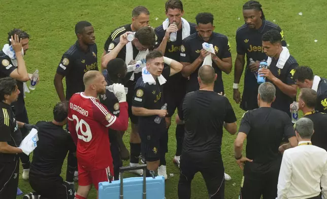 Juventus players receive direction from a coach during a water break in the Club World Cup round of 16 soccer match between Real Madrid and Juventus in Miami Gardens, Fla., Tuesday, July 1, 2025. (AP Photo/Marta Lavandier)