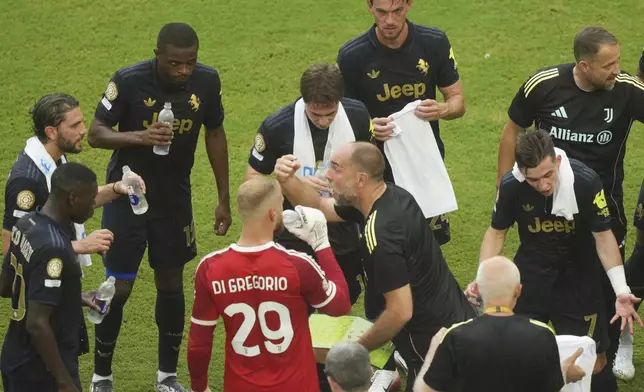 Juventus manager Igor Tudor, center, talks with his players during a water break in the Club World Cup round of 16 soccer match between Real Madrid and Juventus in Miami Gardens, Fla., Tuesday, July 1, 2025. (AP Photo/Marta Lavandier)