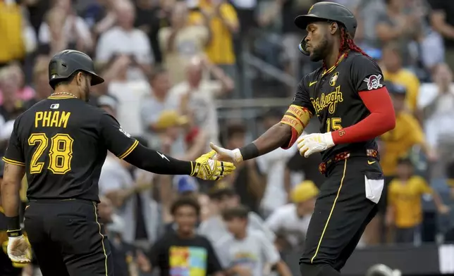 Pittsburgh Pirates' Oneil Cruz, right, is greeted by Tommy Pham, left, after hitting a two-run home run during the second inning of a baseball game against the Arizona Diamondbacks Saturday, July 26, 2025, in Pittsburgh. (AP Photo/Matt Freed)