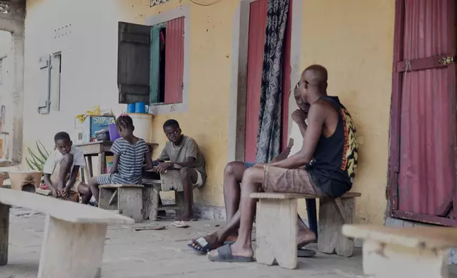 Relatives of late 15-year-old Jacques Koami Koutoglo, sit outside their house as they mourn in Lome, Togo, Monday, July 7, 2025. (AP Photo/Erick Kaglan)