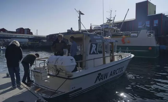 Passengers and tour guide on a tour boat of Raw Arctic at a harbour in Nuuk, Greenland, Wednesday, June 18, 2025. (AP Photo/Kwiyeon Ha)