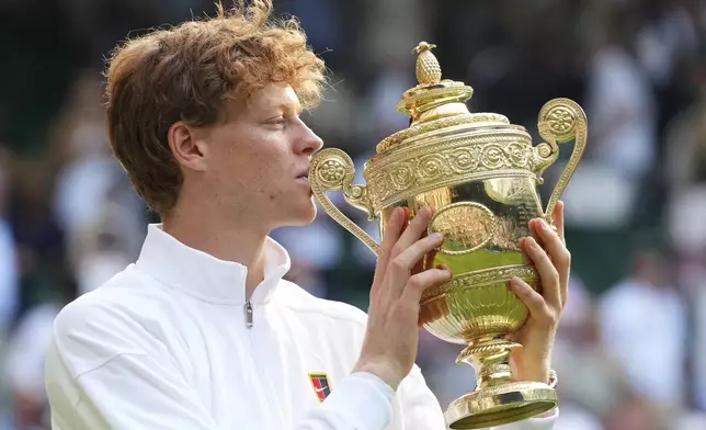 Jannik Sinner of Italy holds the trophy after winning the men's singles final match against Carlos Alcaraz of Spain at the Wimbledon Tennis Championships in London, Sunday, July 13, 2025.(AP Photo/Kirsty Wigglesworth)