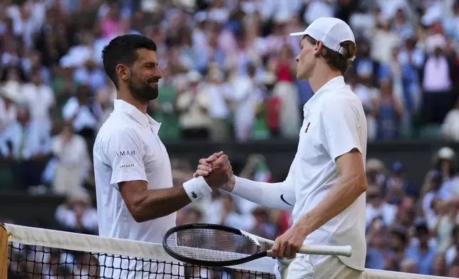 Jannik Sinner of Italy and Novak Djorkovic of Serbia shake hands after the men's semifinal singles match at the Wimbledon Tennis Championships in London, Friday, July 11, 2025.(AP Photo/Joanna Chan)