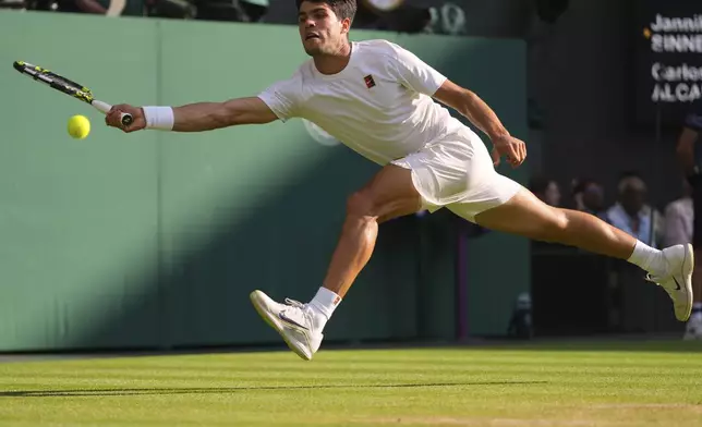 Carlos Alcaraz of Spain returns to Jannik Sinner of Italy during the men's singles final match at the Wimbledon Tennis Championships in London, Sunday, July 13, 2025.(AP Photo/Kirsty Wigglesworth)