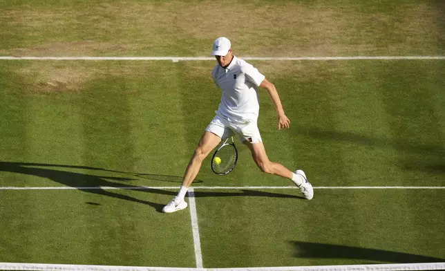 Italy's Jannik Sinner returns to Carlos Alcaraz of Spain in the men's singles final at the Wimbledon Tennis Championships in London, Sunday, July 13, 2025. (AP Photo/Joanna Chan)