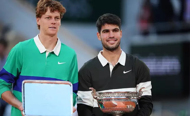 FILE - Winner Spain's Carlos Alcaraz, right, and second placed Italy's Jannik Sinner pose with trophies after the final match of the French Open tennis tournament at the Roland-Garros stadium in Paris, Sunday, June 8, 2025. (AP Photo/Lindsey Wasson, File)