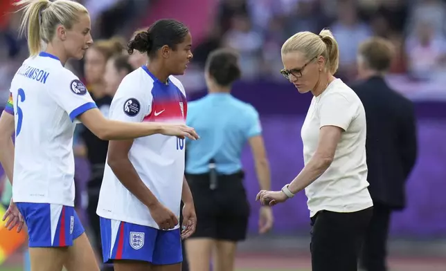 England's Jess Carter speaks to England head coach Sarina Wiegman during the Euro 2025, group D, soccer match between England and the Netherlands at Stadion Letzigrund in Zurich, Switzerland, Wednesday, July 9, 2025. (AP Photo/Alessandra Tarantino)