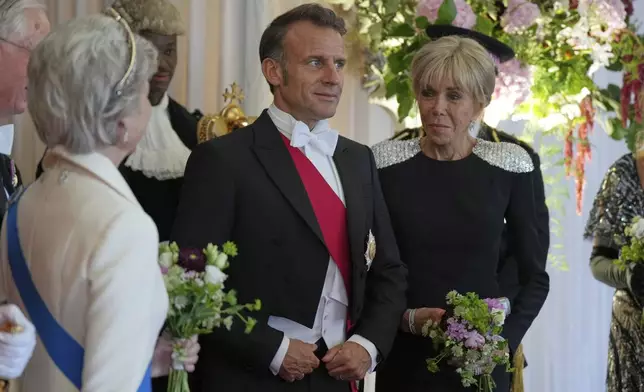 French President Emmanuel Macron, center, and his wife Brigitte, arrive at the Guildhall banquet in London, Wednesday, July 9, 2025. (AP Photo/Alastair Grant)