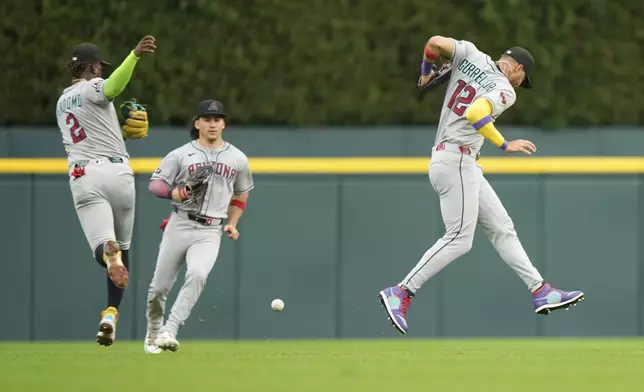 Arizona Diamondbacks left fielder Lourdes Gurriel Jr., right, deflects a single hit by Detroit Tigers' Spencer Torkelson as shortstop Geraldo Perdomo, left, and centerfielder Alek Thomas, center, react during the first inning of a baseball game Monday, July 28, 2025, in Detroit. (AP Photo/Ryan Sun)