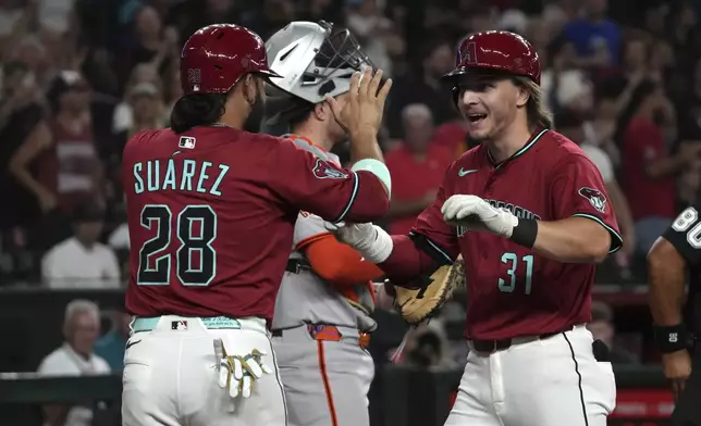 Arizona Diamondbacks' Jake McCarthy celebrates with Eugenio Suarez (28) after hitting a three-run home run against the San Francisco Giants in the fourth inning during a baseball game, Tuesday, July 1, 2025, in Phoenix. (AP Photo/Rick Scuteri)