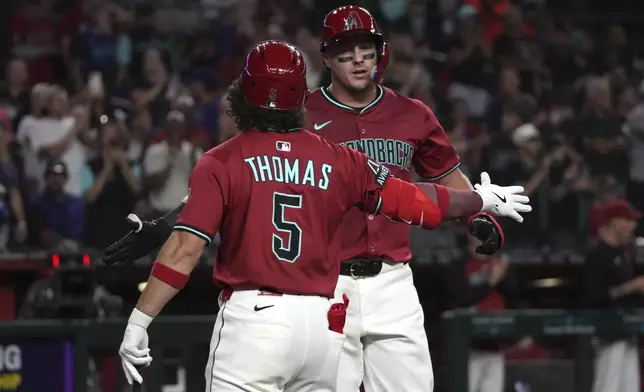Arizona Diamondbacks' James McCann celebrates with Alek Thomas (5) after hitting a solo home run against the San Francisco Giants in the sixth inning during a baseball game, Tuesday, July 1, 2025, in Phoenix. (AP Photo/Rick Scuteri)