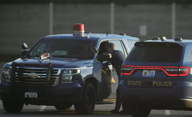 Law enforcement officers are seen stationed outside a Walmart where several people were stabbed in a violent attack Saturday, July 26, 2025, in Traverse City, Mich. (AP Photo/Ryan Sun)