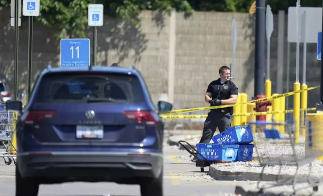 Law enforcement officers investigate outside of a Walmart, Sunday, July 27, 2025, where a multiple stabbing took place on Saturday, in Traverse City, Mich. (AP Photo/Ryan Sun)