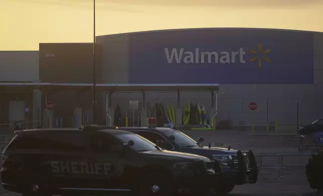 Law enforcement officers are seen stationed outside a Walmart where multiple people were stabbed in a violent attack Saturday, July 26, 2025, in Traverse City, Mich (AP Photo/Ryan Sun)