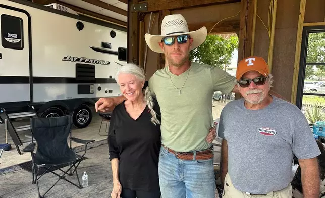 Flood survivors Elizabeth Hastings, left, and Paul Welch, right, stand with volunteer Huntly Dantzler in Comfort, Texas, on Saturday, July 12, 2025. (AP Photo/Gabriela Aoun Angueira)